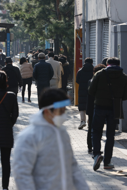 늘어선 검사 대기줄  최근 노량진 학원 집단감염 확진자가 급증하고 있는 가운데 26일 오전 서울 동작구청에 마련된 선별진료소 앞에 검사 대기자들이 줄을 서 있다.    연합뉴스